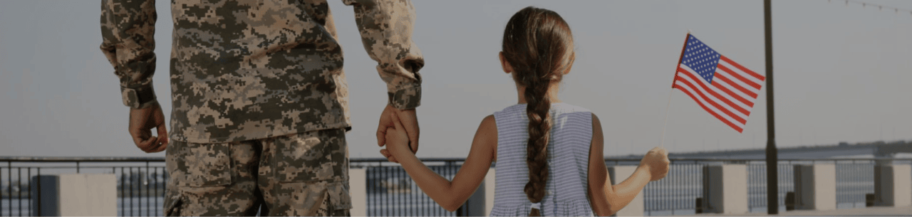In Person kiosks hero image: Vet holding hands with child outside of a military museum