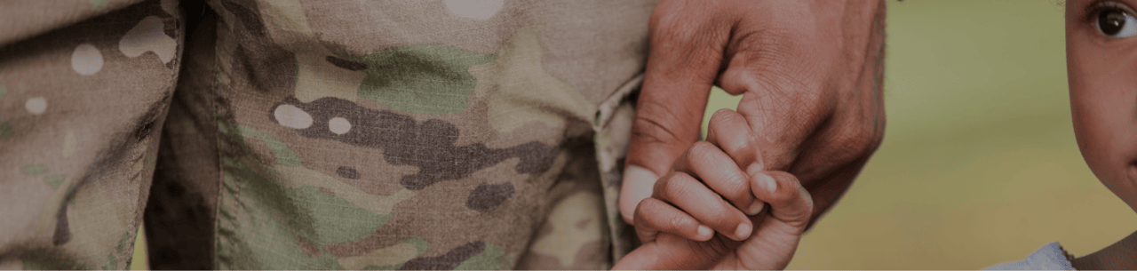 Partnerships hero image: A veteran holding a child's hand